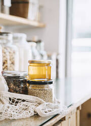 Einmachgläser im Netzbeutel auf dem Tisch im Zero Waste Store - NDEF00127