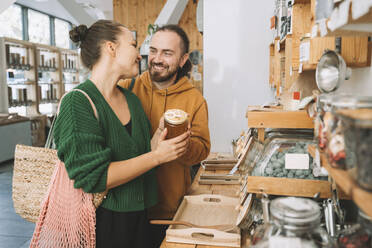 Smiling couple with honey jar in convenience store - NDEF00173