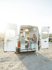 Freelancer working on laptop sitting in motor home - RCPF01499