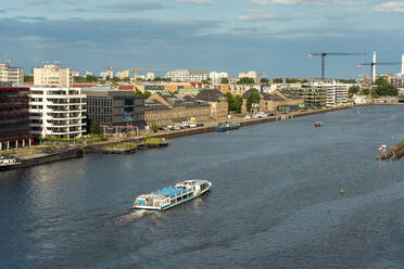 Deutschland, Berlin, Fähre auf der Spree mit Gebäuden des Mediaspree-Viertels im Hintergrund - TAMF03608