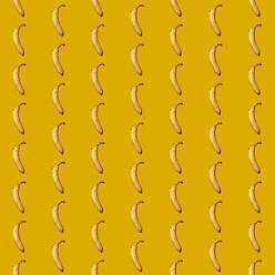 Pattern of bananas flat laid against yellow background - GIOF15651