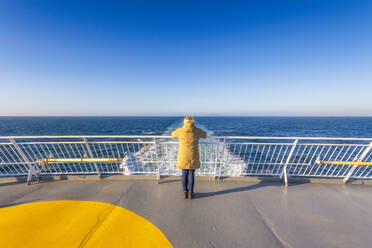 UK, Scotland, Lone woman standing on afterdeck of moving ferry - SMAF02495