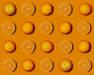 Muster von halbierten Mandarinen flach auf orangefarbenem Hintergrund - GIOF15660