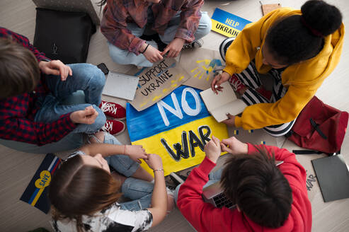 Draufsicht auf jugendliche Schüler, die in einem Klassenzimmer mit Plakaten zur Unterstützung des Konzepts 