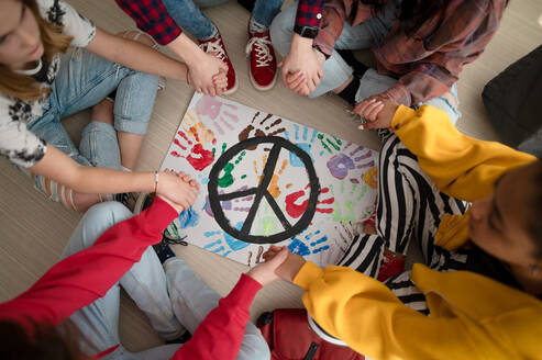 Blick von oben auf Schüler, die in der Schule für den Frieden in der Welt beten. - HPIF00071