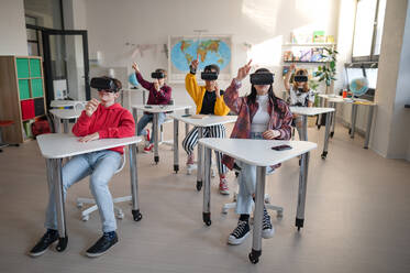 Schüler mit einer VR-Brille an den Tischen im Klassenzimmer, Vorderansicht. - HPIF00092