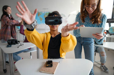 Teenage students wearing virtual reality goggles at school in a computer science class - HPIF00098