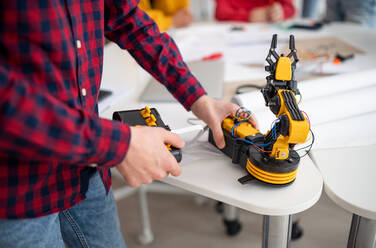 Ein Student konstruiert seinen selbstgebauten Spielzeugroboter in einem naturwissenschaftlichen Robotik-Klassenzimmer in der Schule, Nahaufnahme. - HPIF00149