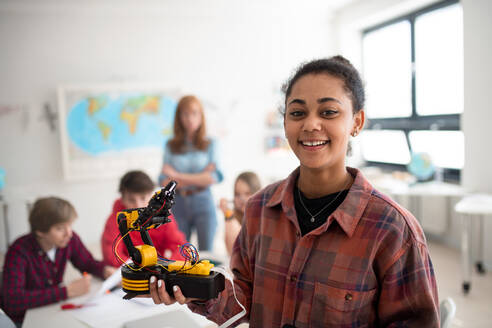 Eine Studentin hält ihr Roboterspielzeug im Robotik-Klassenzimmer der Schule. - HPIF00151