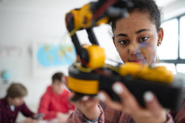 Eine Studentin hält ihr Roboterspielzeug im Robotik-Klassenzimmer der Schule. - HPIF00153