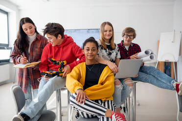 Eine Gruppe von Schülern sitzt und posiert zusammen in einem Robotik-Klassenzimmer - HPIF00156