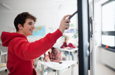 A college student explaining some ideas on a touch TV in classroom. - HPIF00162