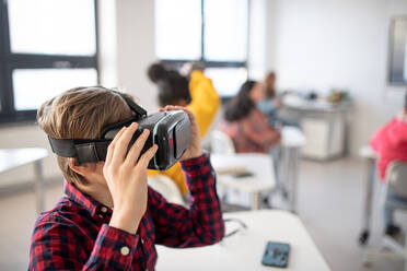 Curious student wearing virtual reality goggles at school in a computer science class - HPIF00166