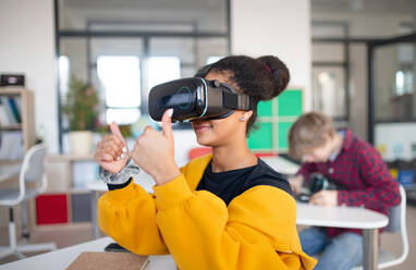 A happy student wearing virtual reality goggles at school in computer science class - HPIF00167