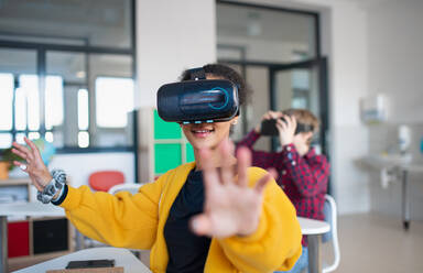 Teenage students wearing virtual reality goggles at school in a computer science class - HPIF00168