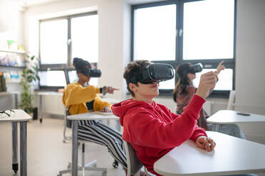 Jugendliche, die in der Schule im Informatikunterricht eine Virtual-Reality-Brille tragen - HPIF00169