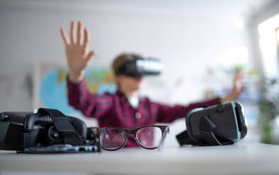 Ein glücklicher Schüler trägt eine Virtual-Reality-Brille in der Schule im Informatikunterricht, Nahaufnahme der Brille. - HPIF00174