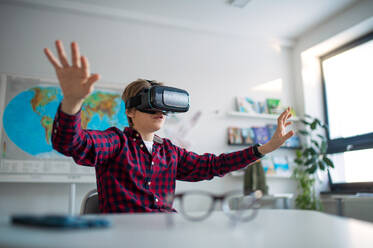 Curious student wearing virtual reality goggles at school in a computer science class - HPIF00175