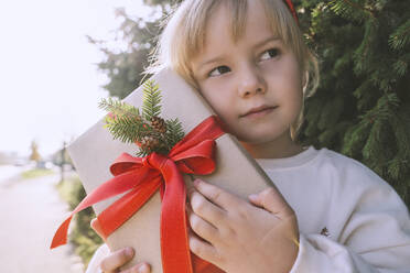 Nachdenkliches Mädchen hält Weihnachtsgeschenkbox - NDEF00234