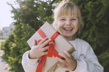 Fröhliches Mädchen mit Weihnachtsgeschenkbox - NDEF00237