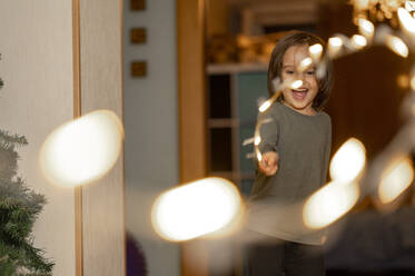 Glücklich niedlichen Jungen spielen mit String Licht zu Hause - ANAF00582
