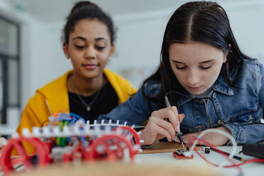 A high school students building and programming electric toys and robots at robotics classroom - HPIF00230