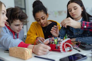 Eine Gruppe von Oberstufenschülern baut und programmiert elektrische Spielzeuge und Roboter im Robotik-Klassenzimmer - HPIF00233