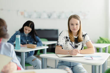 Junior high school students enjoying lesson at desks in classroom Stock  Photo - Alamy