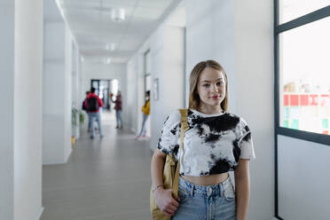 Junge Gymnasiastin geht in einem Korridor in der Schule, zurück zu Schule Konzept. - HPIF00266