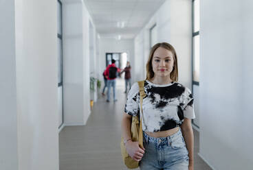 Junge Gymnasiastin geht in einem Korridor in der Schule, zurück zu Schule Konzept. - HPIF00267