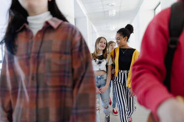 Junge Gymnasiasten, die in einem Korridor in der Schule spazieren gehen, Konzept 