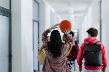 Eine Rückansicht junger Gymnasiasten, die auf dem Schulflur spazieren gehen, ein Konzept für den Schulanfang. - HPIF00271