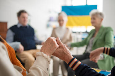 A group of seniors praying for Ukraine together in church community center. - HPIF00346