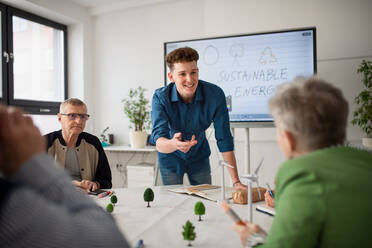 Eine Gruppe von Oberstufenschülern diskutiert mit einem Lehrer im Klassenzimmer über alternative Energien. - HPIF00411