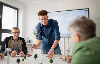 Eine Gruppe von Oberstufenschülern diskutiert mit einem Lehrer im Klassenzimmer über alternative Energien. - HPIF00412