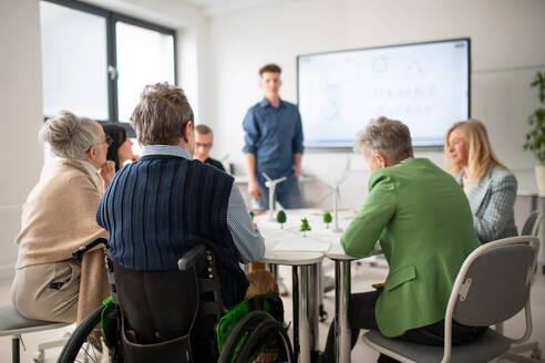 Eine Gruppe von Oberstufenschülern diskutiert mit einem Lehrer im Klassenzimmer über alternative Energien. - HPIF00416