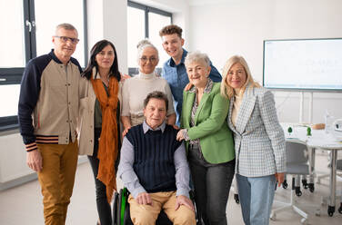 Happy senior students meeting with their friend on wheelchair at university. Social inclusion and university of third age concept. - HPIF00428