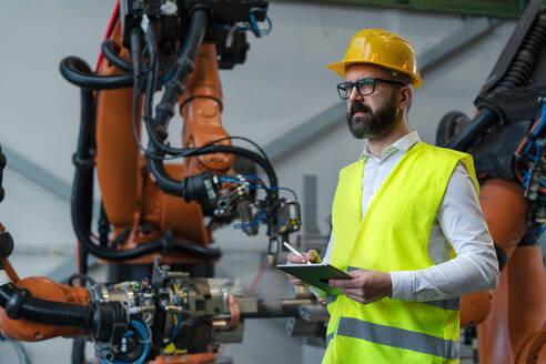 Ein Automatisierungsingenieur hält einen Scanner in einer Fabrik in der Hand. - HPIF00604
