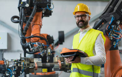 An automation engineer holding scanner in industrial in factory. - HPIF00605