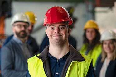 A young man with Down syndrome working in industrial factory, social integration concept. - HPIF00610