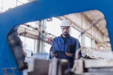 Ein technischer Leiter und ein Mechaniker bei einer Routinekontrolle in einer Industrieanlage - HPIF00625