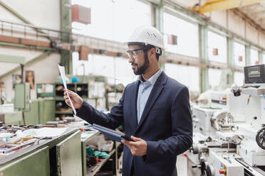 An engineering manager and mechanic worker doing routine check up in industrial factory - HPIF00638