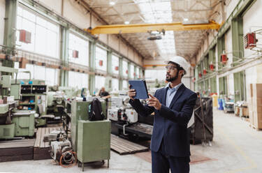 Ein technischer Leiter und ein Mechaniker bei einer Routinekontrolle in einer Industrieanlage - HPIF00642