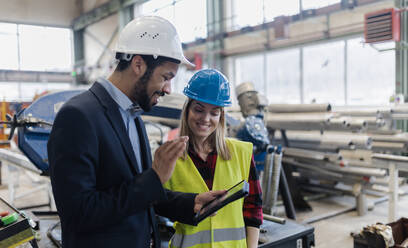 Ein technischer Leiter und ein Mechaniker führen eine Routinekontrolle in einer Industrieanlage durch und führen ein Videogespräch. - HPIF00643