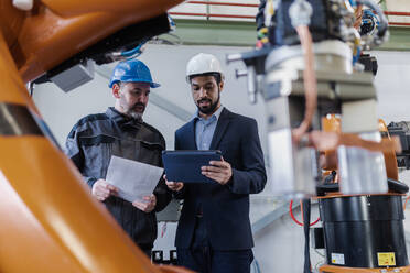 An engineering manager and mechanic worker doing routine check up in industrial factory - HPIF00644