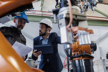 Ein technischer Leiter und ein Mechaniker bei einer Routinekontrolle in einer Industrieanlage - HPIF00645