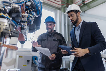 Ein technischer Leiter und ein Mechaniker bei einer Routinekontrolle in einer Industrieanlage - HPIF00646