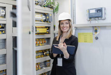 Ein Porträt eines weiblichen Chefingenieurs in einer modernen Industriefabrik, der ein Tablet benutzt. - HPIF00651