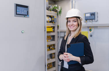 Ein Porträt eines weiblichen Chefingenieurs in einer modernen Industriefabrik, der ein Tablet benutzt. - HPIF00652