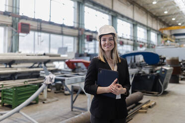 A portrait of female chief engineer in modern industrial factory using tablet. - HPIF00654